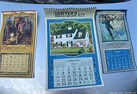 Three old wall calendars laid out showing January 1940 Sawyer's calendar in center and 1931 and 1932 National Safety Council calendars flanking.