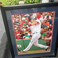 Close-up of the signed photo of Mike Lowell batting, with visible autograph and crowd background.