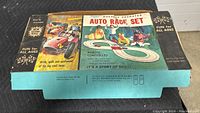 Front and top view of the closed original box showcasing vintage artwork and labeling detailing the battery-operated auto race set by Ungar from the 1960s.