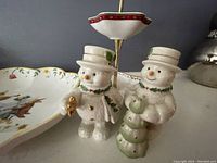 Lenox snowmen salt and pepper shakers showing two snowmen with hats and scarves, gold accent details.