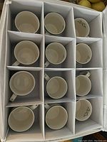 Top-down view of one padded case holding 12 porcelain Christmas Tree cups arranged in compartments