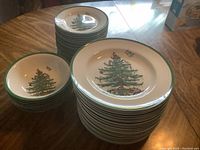 Stacks of dinner plates, salad plates, and bowls with Spode Christmas Tree pattern