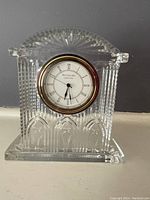 Full frontal view of Waterford crystal clock with detailed etching, showing clock and gold-tone bezel.
