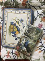 Floral patterned tablecloth with placemats and peacock napkins displayed on top