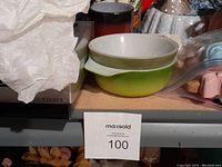 Green and white ceramic bowl on shelf with MaxSold tag