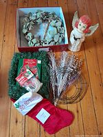 Photo showing all items: Martha Stewart wreath in box, green lighted garland in packaging, blow mold angel figurine, red stocking, wire wreath frames, and craft picks.