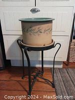 Full view of wrought iron plant stand holding the ceramic pot, showing height and structural details.