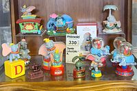 Full display of Dumbo collectibles including figurines, snow globes, toys, and clock.