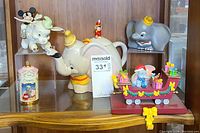 Photo showing Dumbo and Timothy Mouse teapot, Dumbo stocking holder, Mickey Mouse Lenox figurine, Dumbo spice jar, and Dumbo character on a festive toy train