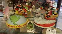 Photo of three Disney holiday figurines: a 1982 limited edition Mickey and Donald sleigh on a snow base, a 1991 Merry Christmas globe with Mickey, Donald, and Goofy, and a bone china Bambi half egg figurine.