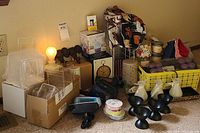 Image showing assorted home decor and self care items including boxed aroma diffuser, crosses vintage metal alarm clock, scarves, candles, headbands, and acrylic display stands