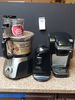Photo showing Hamilton Beach food processor, Black & Decker can opener, and Keurig coffee maker side by side on countertop