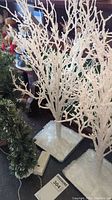 Photo of white flocked Christmas tree with battery pack base and snowy textured base