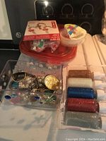 Top view showing small containers of glitter, a box of assorted beads including faux pearls, and small packaged items possibly hooks or additional supplies.