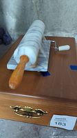 Marble rolling pin with wooden handle placed on a wooden surface