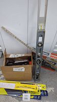 Photo showing metal level, measuring ruler, box with timing light cables and packaged windshield wiper blades