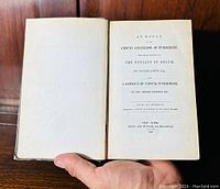 Hand-held open book showing title page with full title, author, publication info dated 1846.