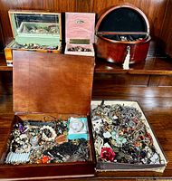 Wide view of three open jewelry boxes and a tray filled with assorted jewelry pieces