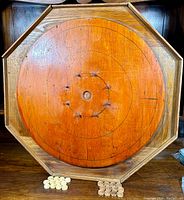 Top-down photo showing octagonal wooden crokinole board with two sets of wooden discs.