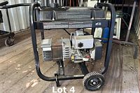 Front angled view of Coleman Powermate MAXA 3000 OHV generator showing frame, wheels, engine, and motor.