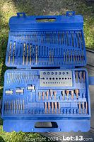 Blue plastic case opened showing multiple compartments filled with assorted drill bits and accessories.