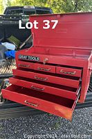 Red Gray Tools toolbox open showing multiple drawers and hinged top compartment, with a lock and key.