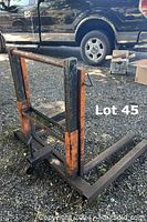 Metal dolly for transporting large truck tires with visible wear and rust on orange and black paint.