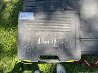 Closed black hard plastic case with 'Lot 12' label and yellow locking clips