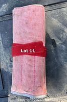 Roll-up pouch holding a 15-piece wrench set, folded and secured with a red strap.