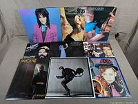 Photo showing the front of all 9 vinyl records with covers featuring Joan Jett, Styx, Harry Chapin, Bob Seger, Stevie Nicks, Huey Lewis, Payolas, Bryan Adams, and Culture Club