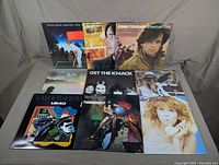 Photo showing the front of all nine vinyl record album covers, with notable artists Elton John, Jackson Browne, John Cougar, Boz Scaggs, The Knack, UB40, Rick James, Powder Blues.