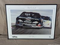 Framed NASCAR race car print of Dale Earnhardt's Monte Carlo Goodwrench car in action with close trailing car, artist Peter Brough's signature visible, framed and matted.