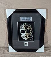Frontal view of the framed image showing the goalie mask and autograph with Boston Bruins plate and logo.