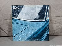 Front cover of Peter Gabriel LP showing raindrops on a blue car door with white text 'peter gabriel' on top left corner.