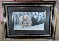 Framed print of a lynx in winter scene, ornate frame with dark and gold trim, print measures 48 x 37.