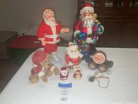 Photo showing all six items on display including Boyds' Bear, multiple Santa figures, and wooden Santa pull toy.