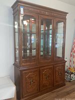 Full view of the Broyhill curio cabinet showing its wood finish and design.