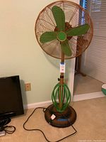 Front view of entire fan showing blades, cage, stand and base