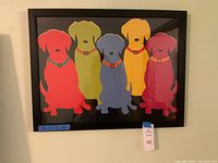 Front view of the framed multicolored Labrador dog print hanging on the wall, showing full artwork and frame with size label.