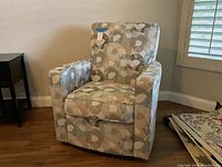 Front view of Dora swivel accent chair showing floral upholstery and cushion design.