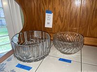 Pair of Waterford crystal bowls on a tiled surface with blue measurement labels (8.5" and 7.25") taped near them.