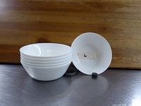 Photo of six stacked white round serving bowls showing the size and shape, clean condition.
