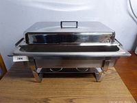 Front angle view of the chafer showing closed lid and stand with three-point welding legs.