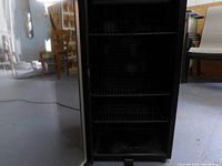 Open view of Danby wine cooler showing multiple black wire shelves inside
