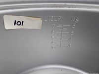 Close-up of the inside of the rice cooker pot showing measuring scale for volume in liters(cups) and kilograms.