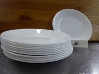 Photo showing stacked set of 7-inch white round Corningware side plates, total twelve plates visible.