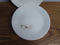Single white Corelle plate with no pattern, measuring approximately 10 inches in diameter.