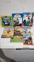 Photo showing 9 children's books including Angry Birds Playground, Thomas the Tank Engine, Beauty and the Beast, Lion King, Dog Man, Dinosaur Dinosaur, The Dinosaur Who Lived in My Backyard, and Lilo & Stitch.