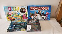 Photo showing four boxed games including The Game of Life, Monopoly Fortnite, Sea Battle, and Personality Workshop.