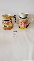 Front view of two vintage ceramic mugs, one with floral design and lantern handle, the other as character mug with top hat.